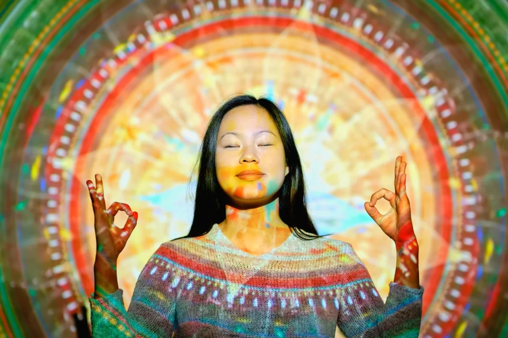 Asian Woman Meditating near the Mandala